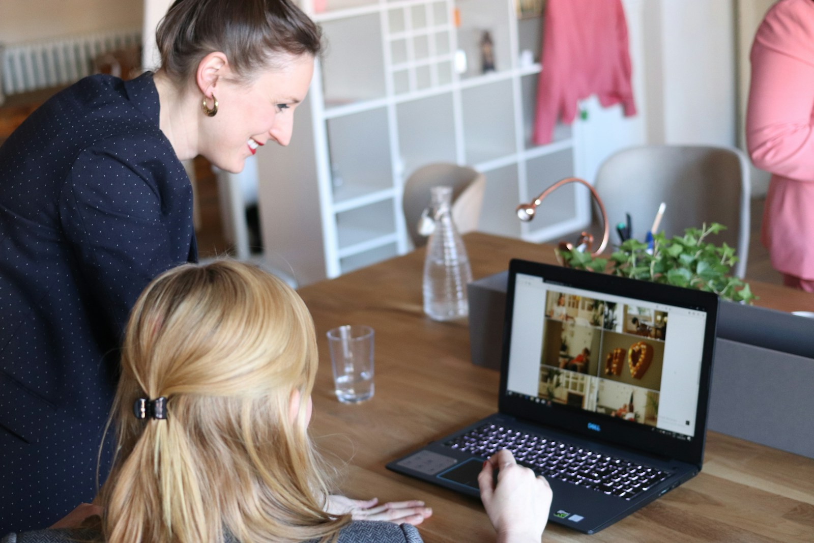 Frauen besprechen Website-Inhalte an einem Laptop in Berlin